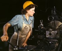 Woman working at an industrial lathe.